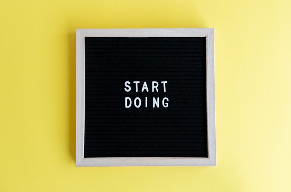 Black message board with 'Start Doing' on a bright yellow background for inspiration.